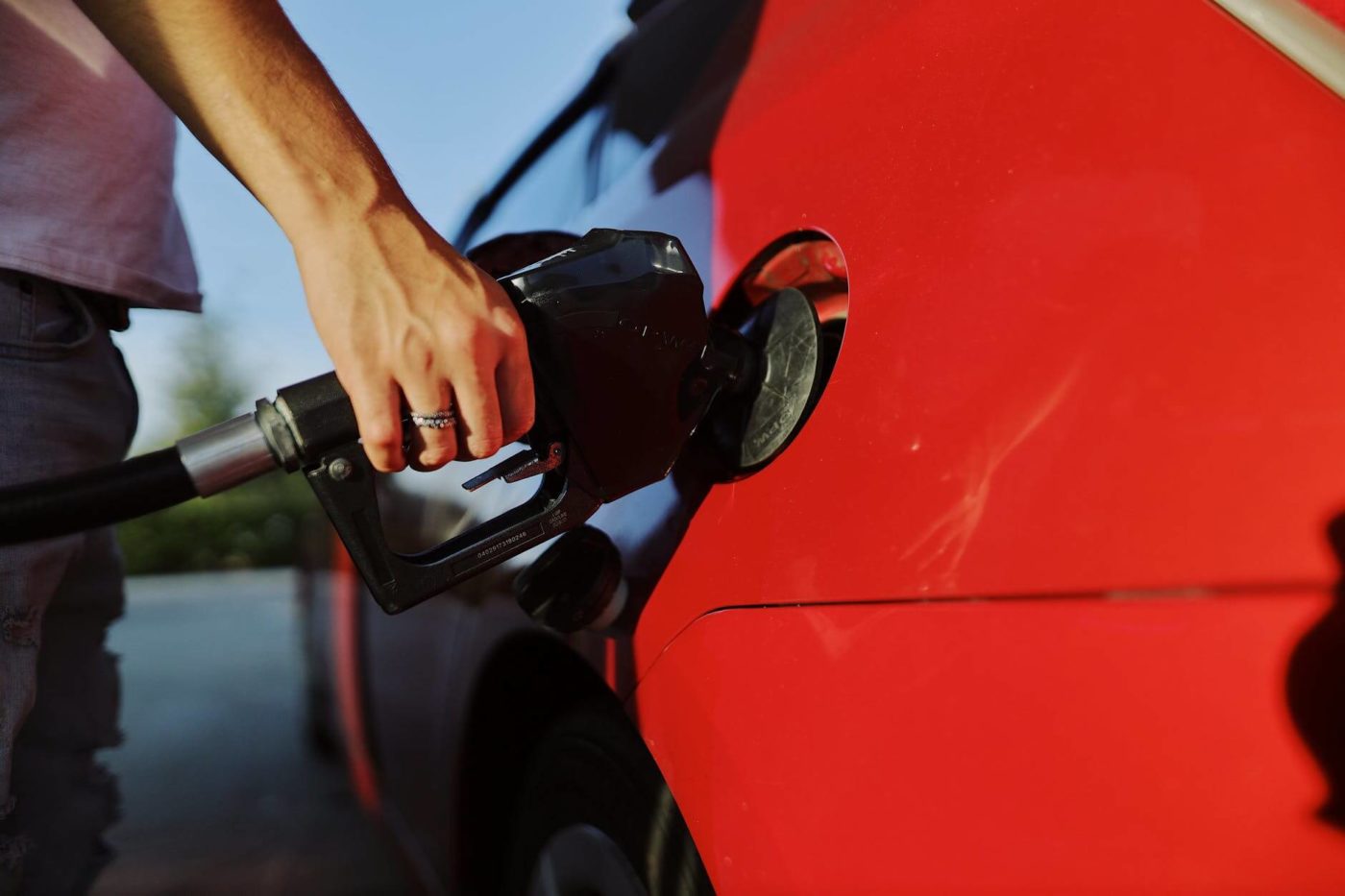 A man filling up a car's tank before professional auto transport