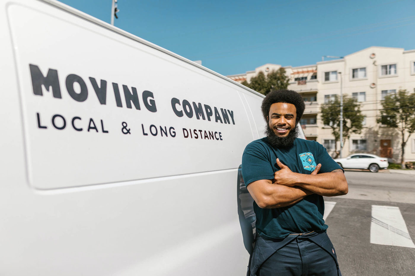 a mover smiling and standing in front of a relocation van