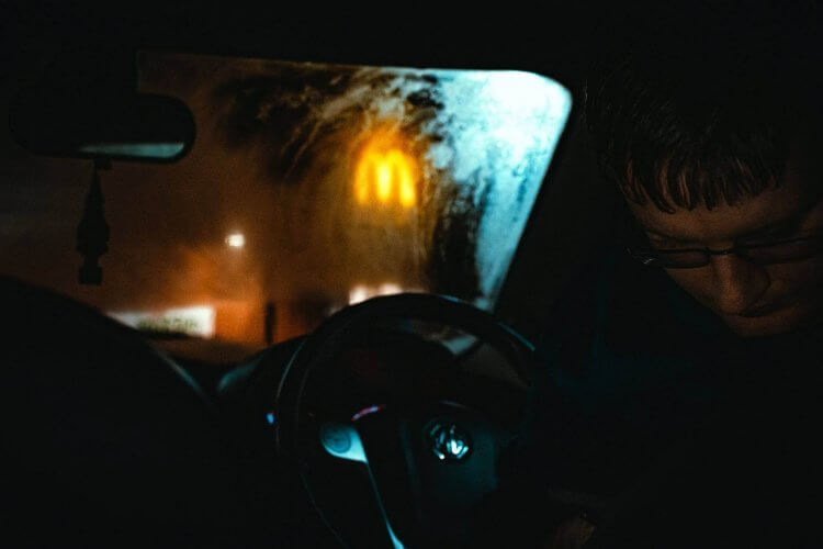 A man in the car in front of a McDonald's restaurant