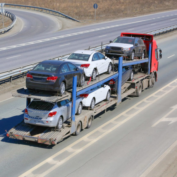 Cars on an open trailer during long-distance car shipping