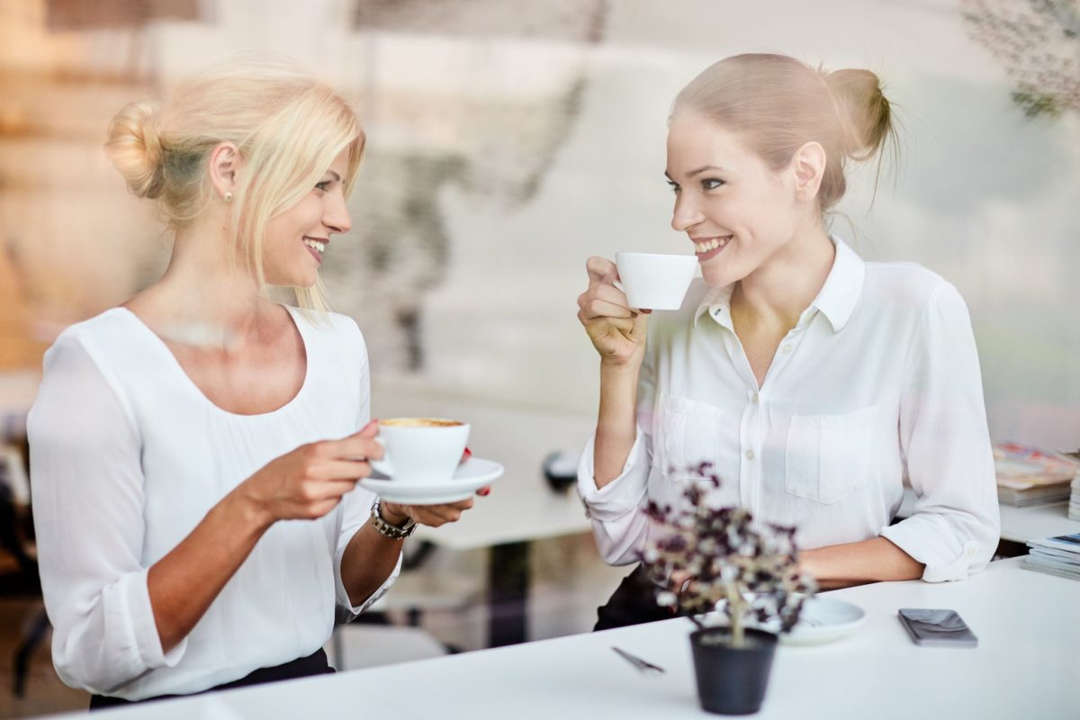 Two girls talking about former tenants while drinking coffee