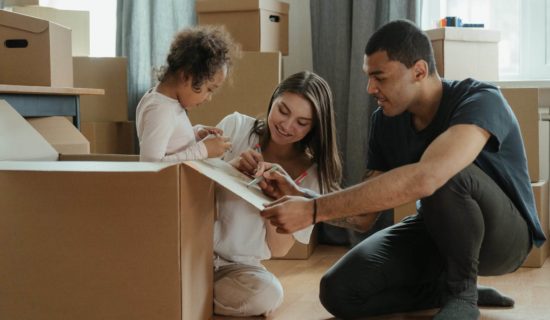 Family unpacking moving boxes in living room