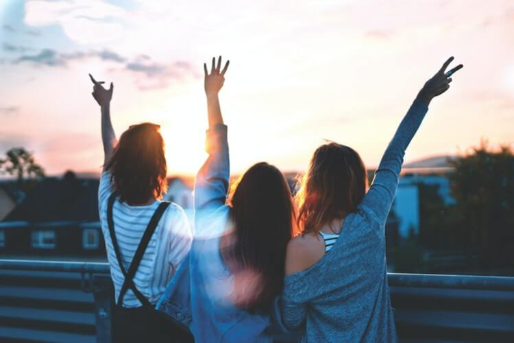 three girls with raised hands