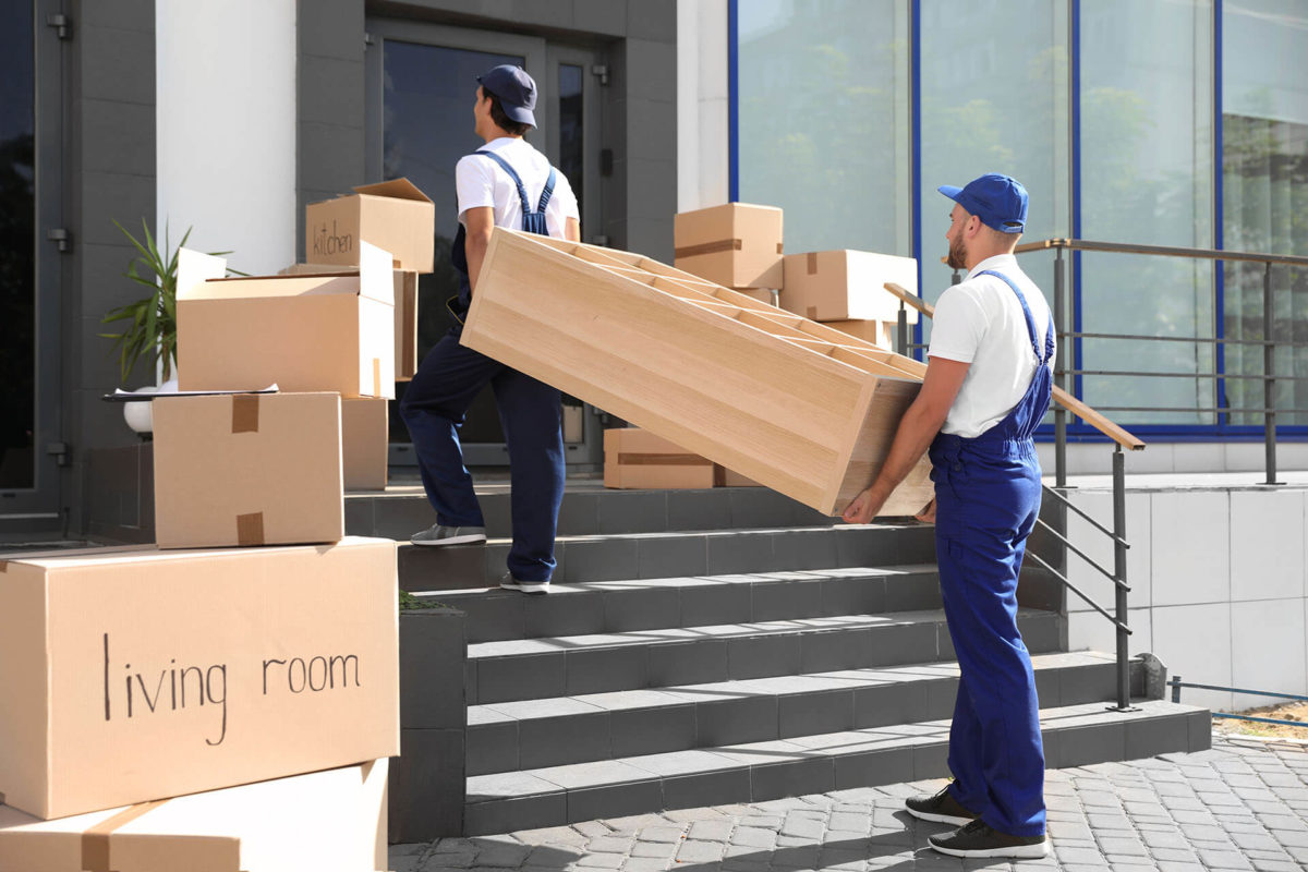 two long-distance movers carrying a large case