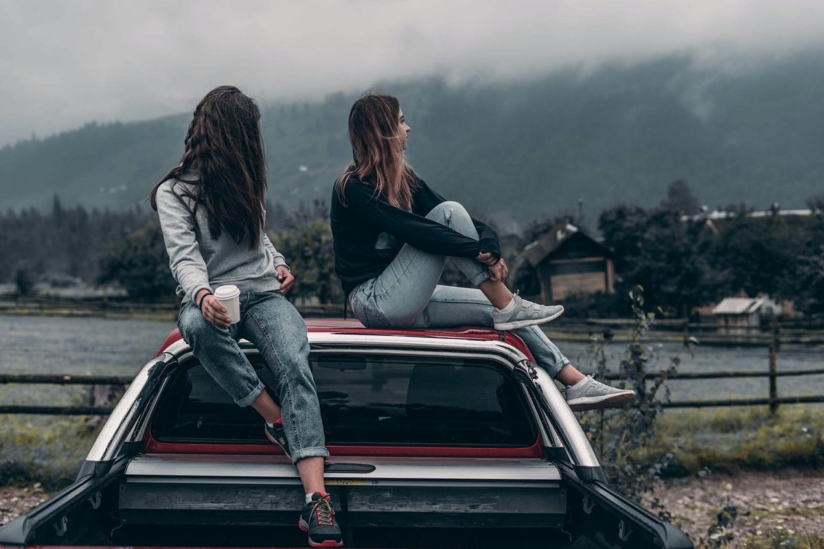 Girls sitting on a car after car shipping