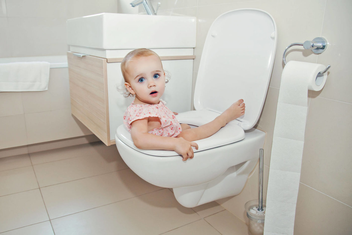 A baby that has fallen in the toilet looking at the camera