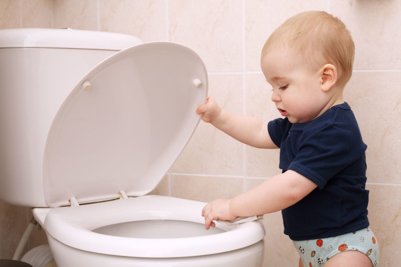 A kid playing with a toilet bowl