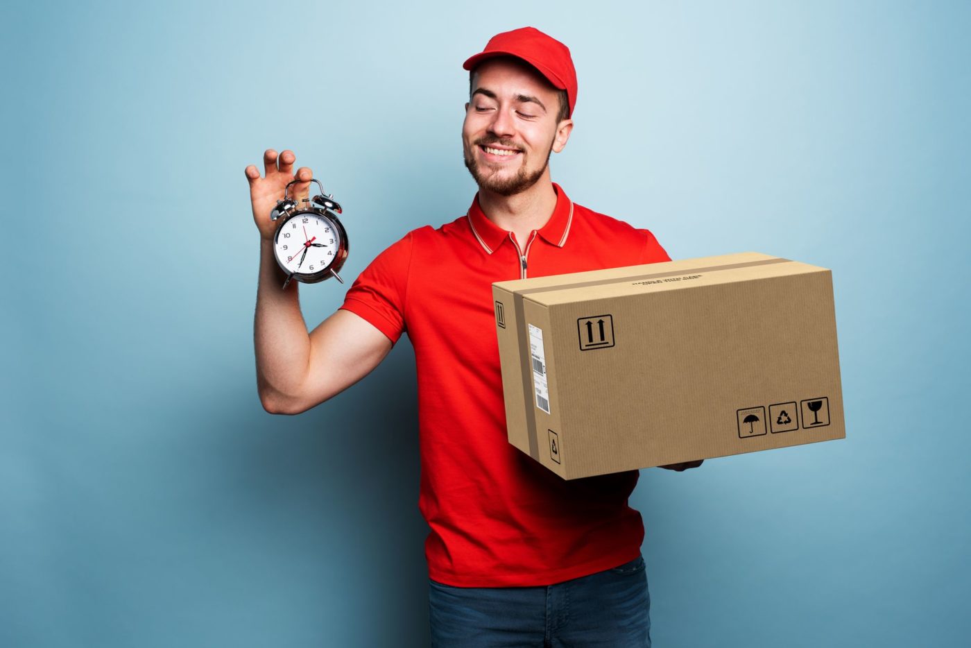 A mover holding a clock and a box and smiling