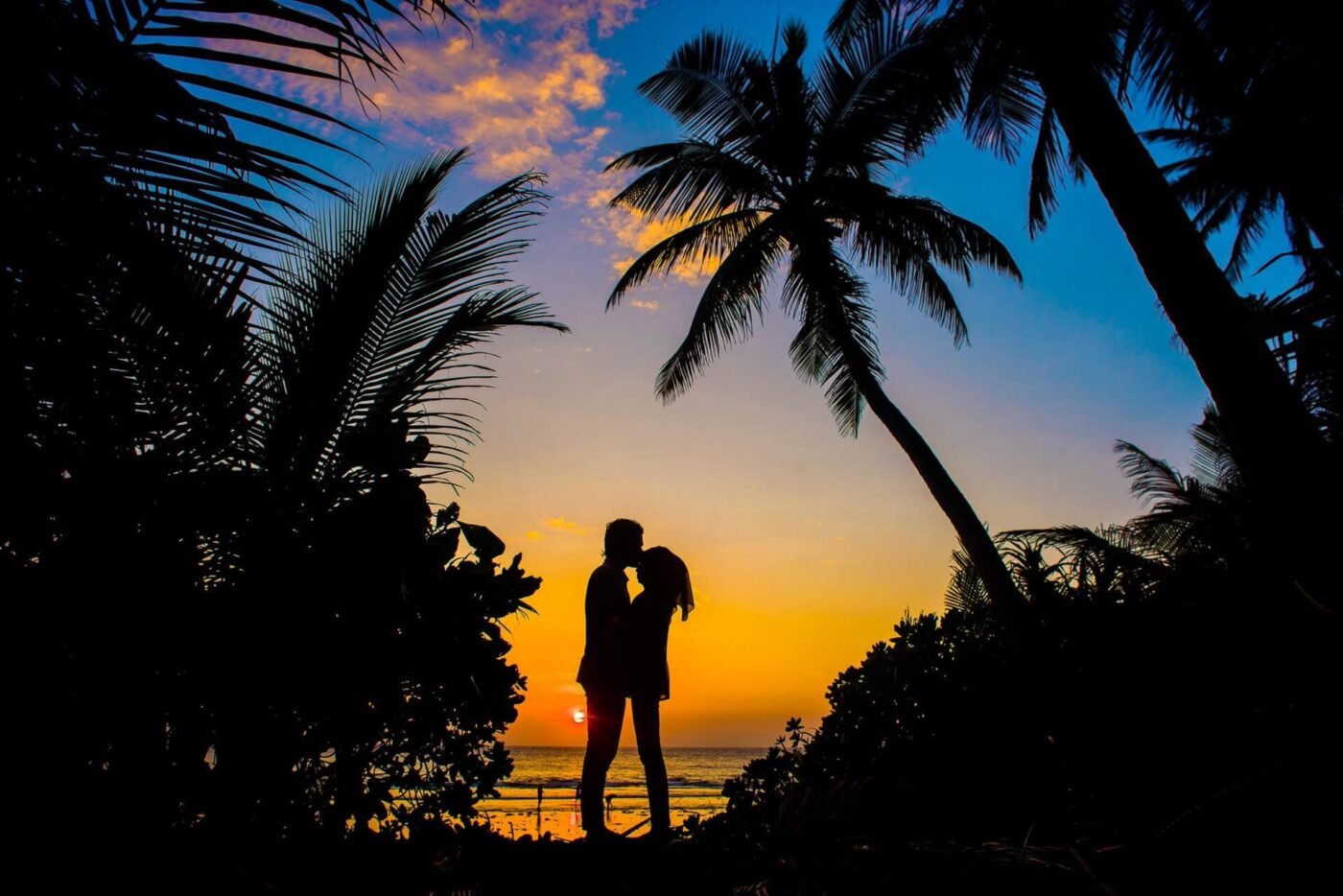 a couple in front of a sunset