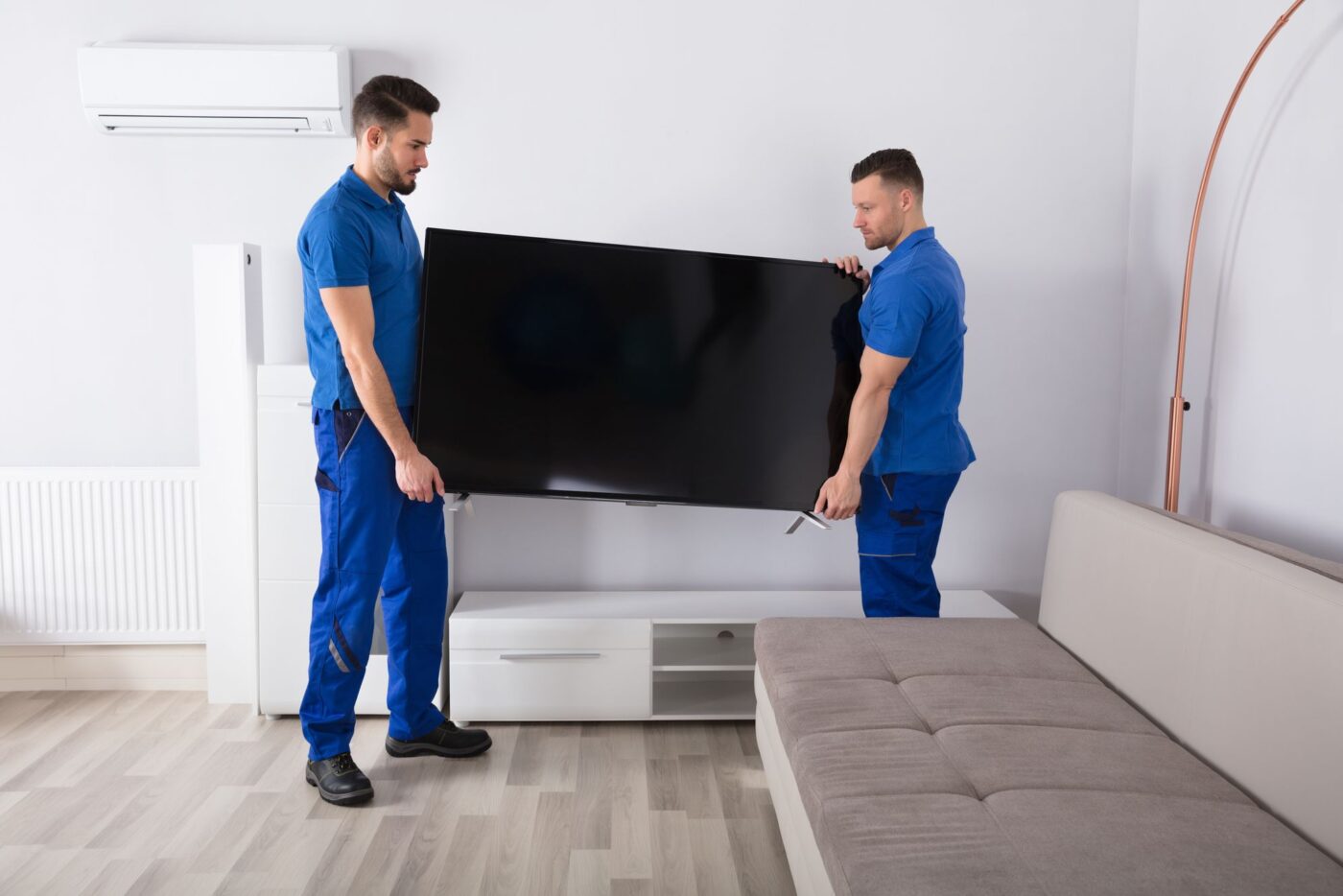 Professional movers relocating a TV