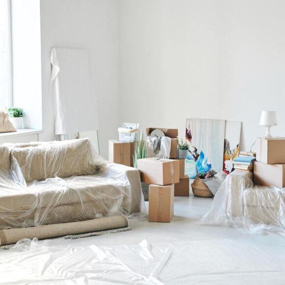A covered sofa and boxes prepared for relocation