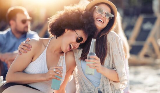Two girls smiling and drinking