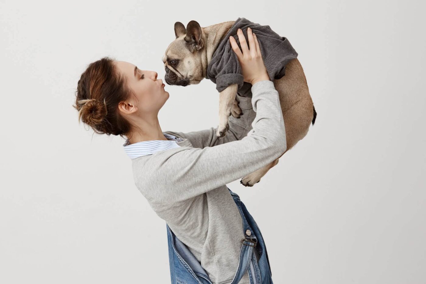 Woman lifting and kissing her dog