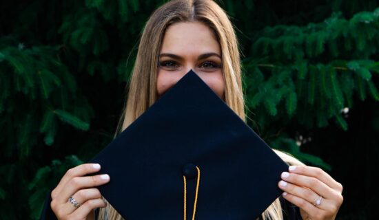 A girl holding a graduation cap before cross-country moving