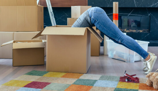 A girl diving deep into a box, preparing for a relocation