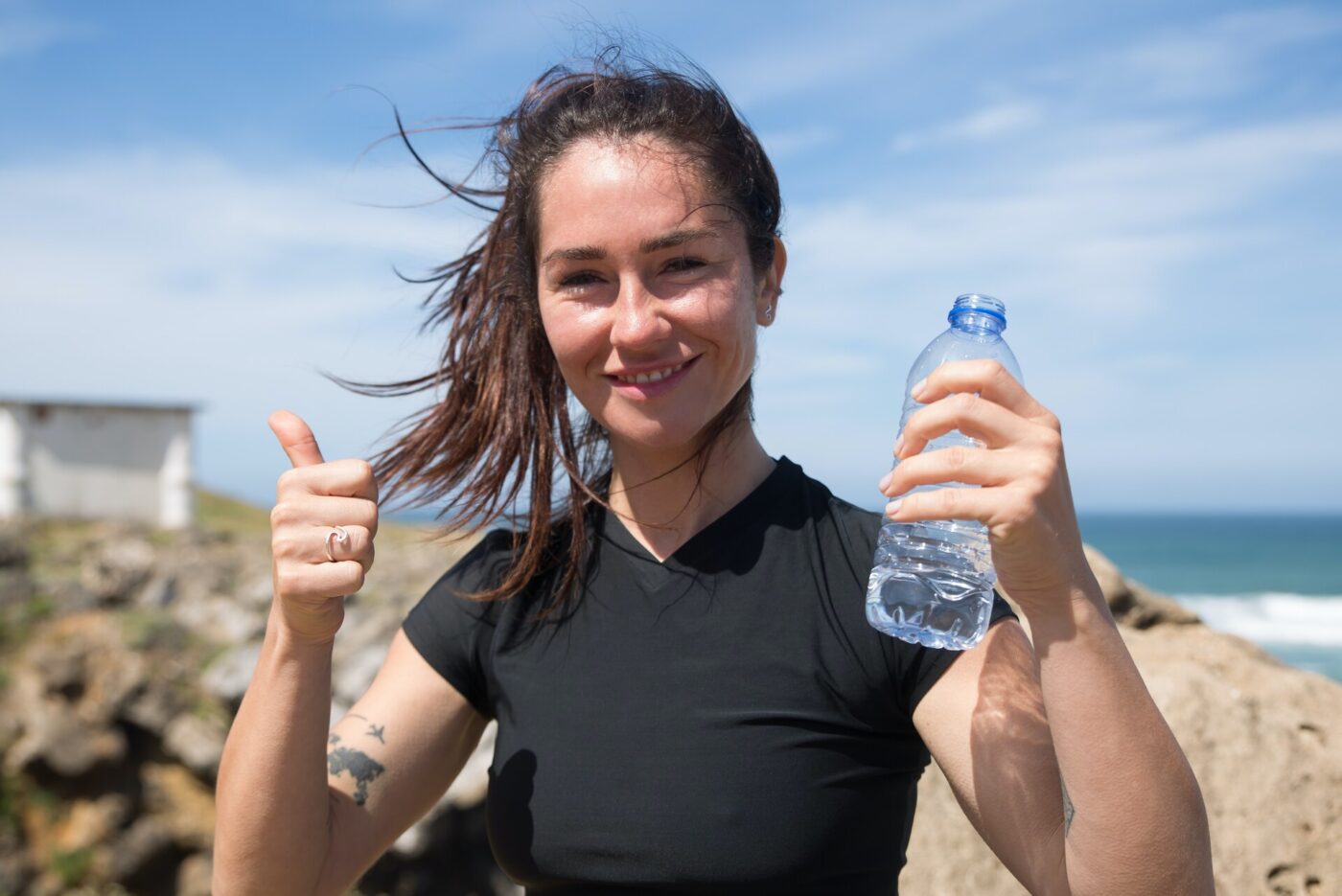 Woman holding a plastic bottle of water outside