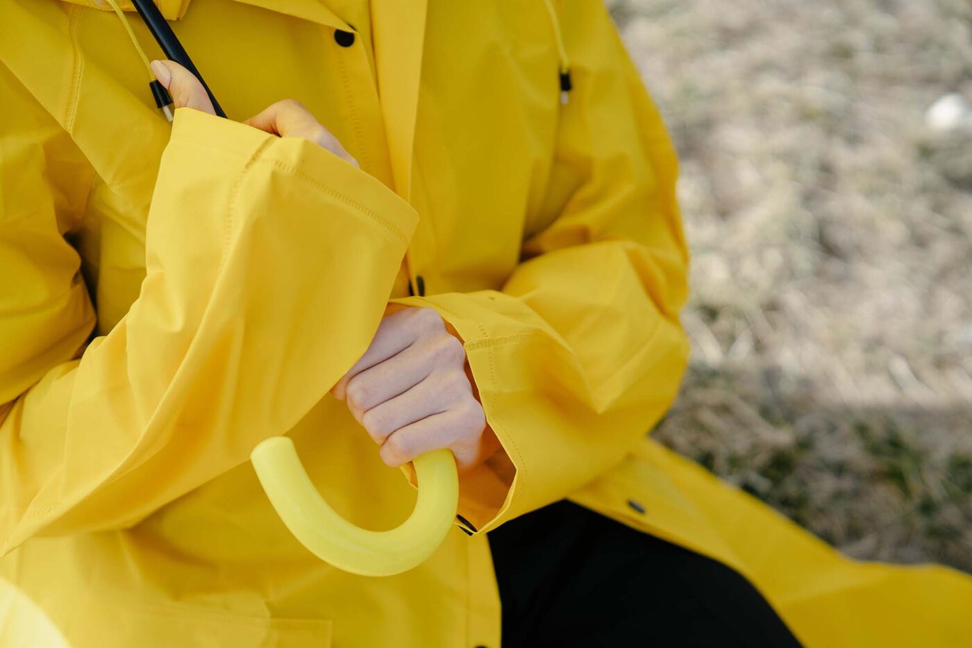 A person wearing a raincoat and holding an umbrella