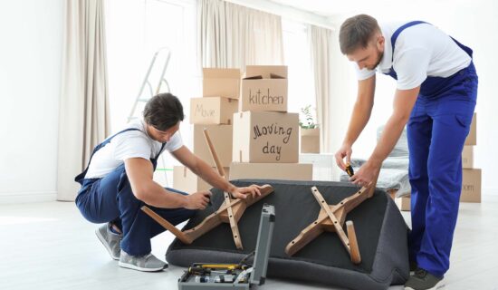 movers assembling sofa in new house