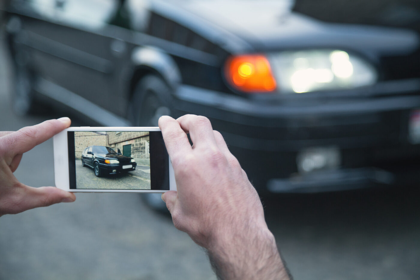 A man taking a photo of his car