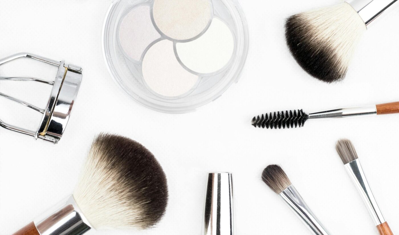 Makeup brushes, eyelash curler, and an eyeshadow palette