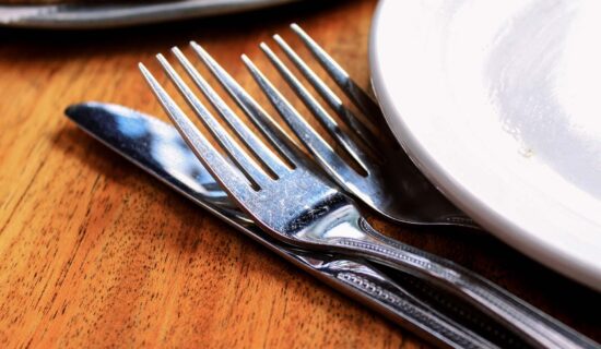 A close up image of a fork and knife silverware set at a restaurant table setting.