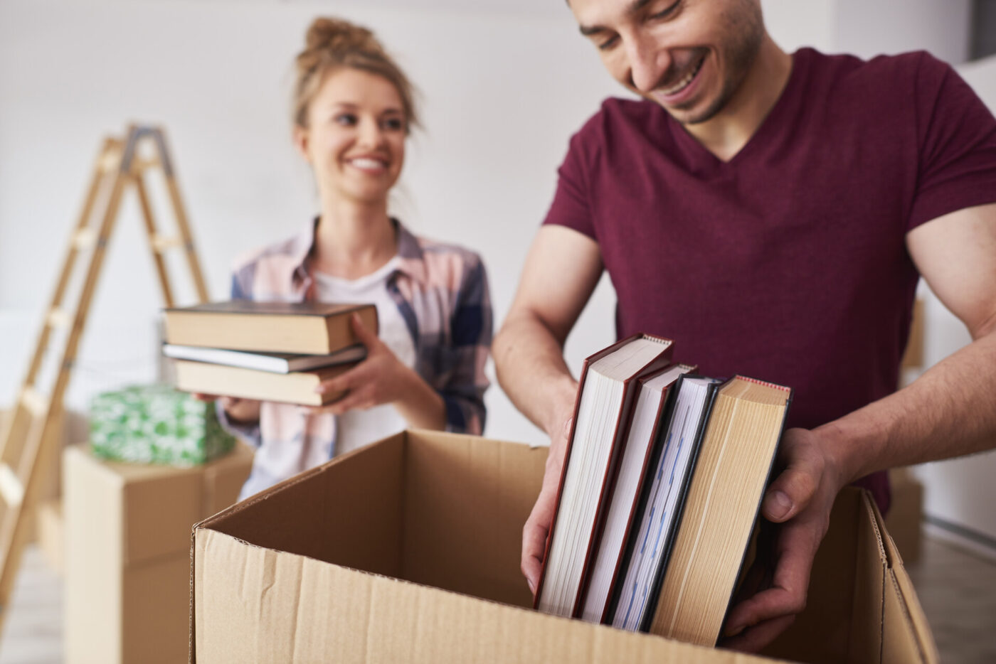 A couple packing books into boxes