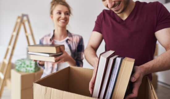 A couple packing books into boxes