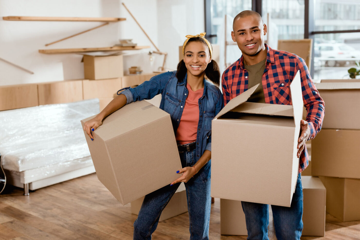 A man and woman carrying boxes