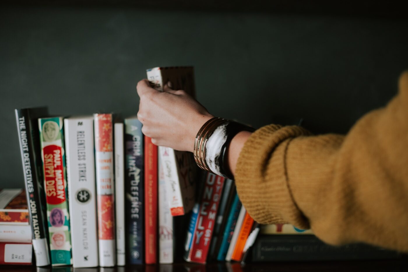 A woman taking a book from a shelf